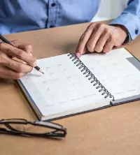 A man writing something down in his schedule/planner
